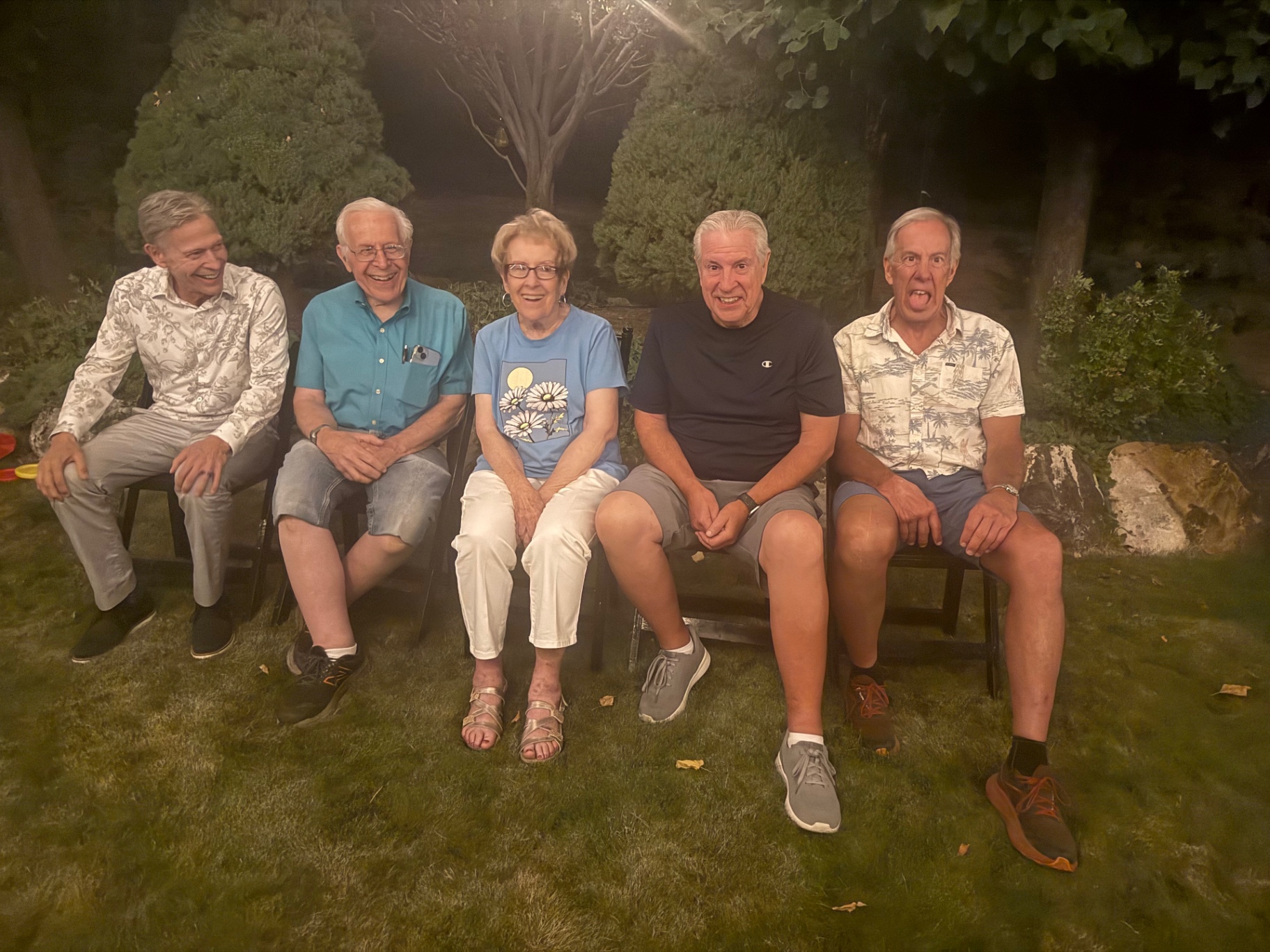The Paul siblings and their mom on a bench in the backyard